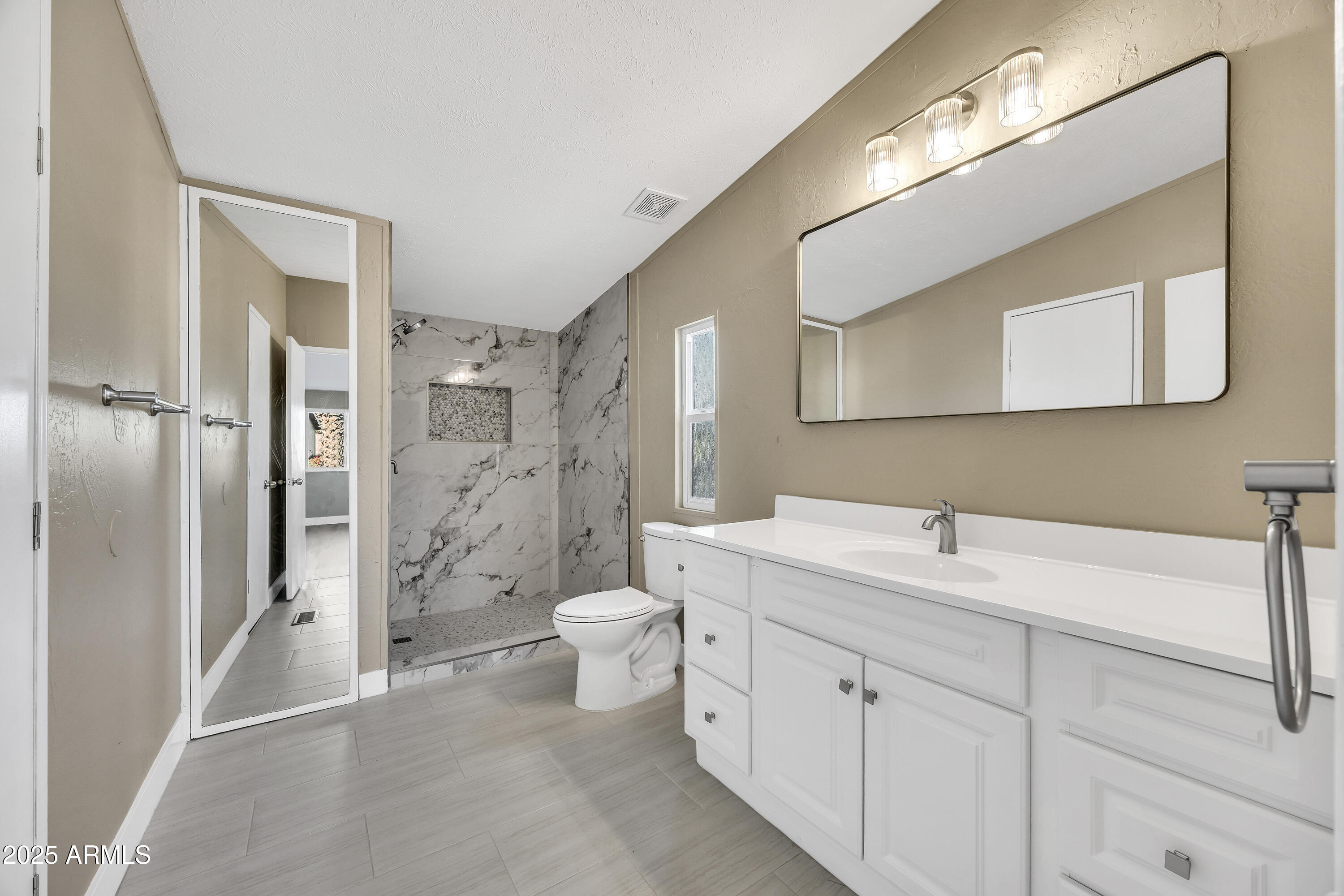 2000 South Apache Road, Unit 220 Buckeye, AZ 85326 - Photo 3 of 25 a spacious bathroom with a double vanity sink mirror and toilet