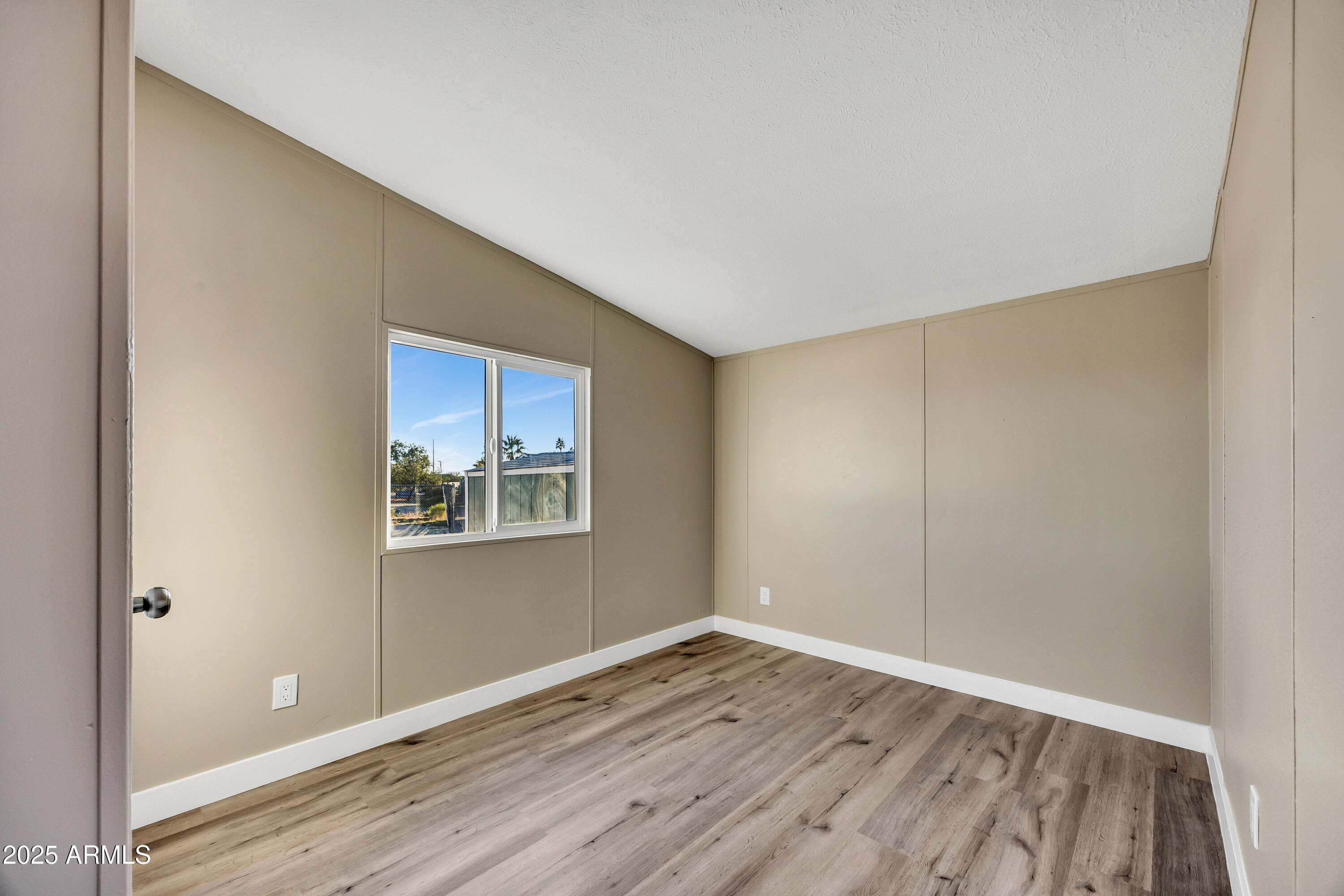 2000 South Apache Road, Unit 220 Buckeye, AZ 85326 - Photo 6 of 25 a view of an empty room with wooden floor and a window