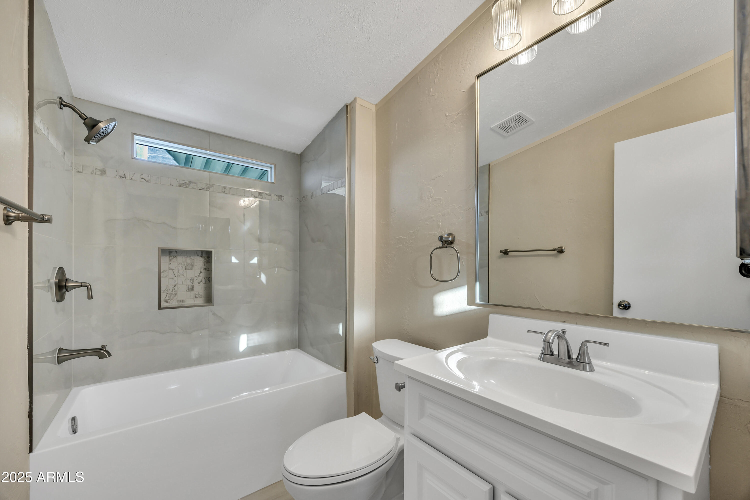 2000 South Apache Road, Unit 220 Buckeye, AZ 85326 - Photo 8 of 25 a bathroom with a bathtub shower sink vanity mirror and toilet