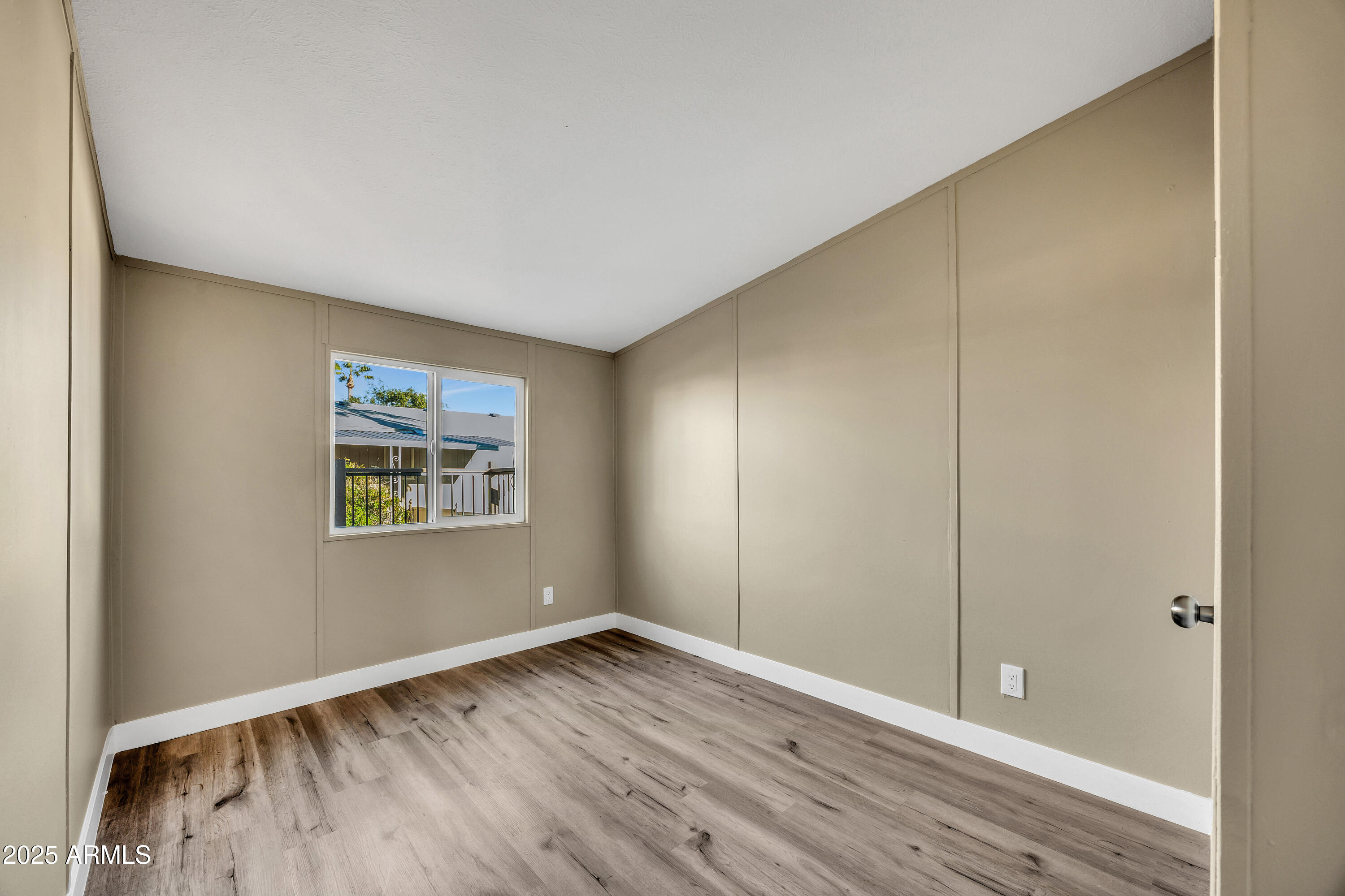 2000 South Apache Road, Unit 220 Buckeye, AZ 85326 - Photo 9 of 25 a view of an empty room with wooden floor and a window