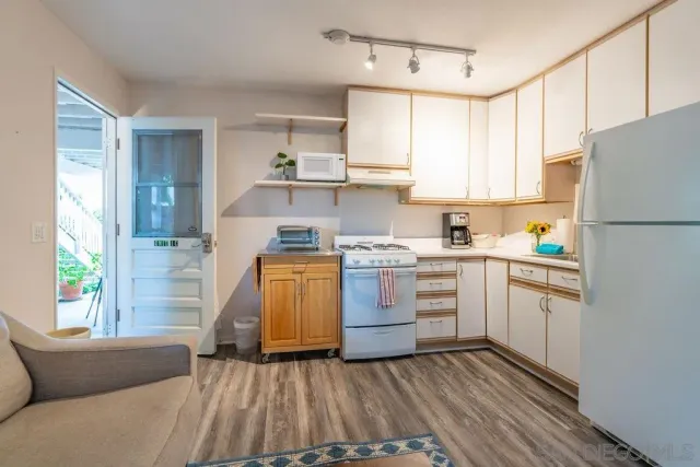 a kitchen with white cabinets and white appliances