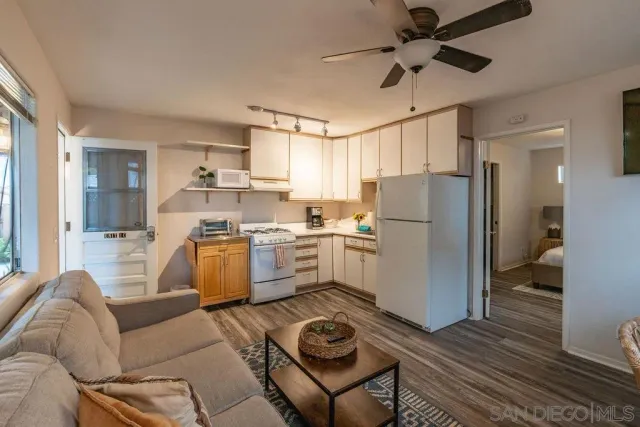 a living room with furniture and a refrigerator