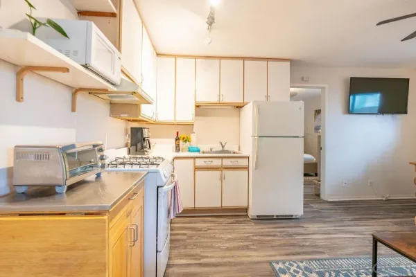 a kitchen with a refrigerator a stove top oven and a sink