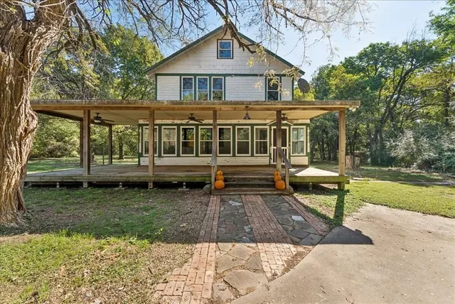 a view of a house with backyard and wooden deck