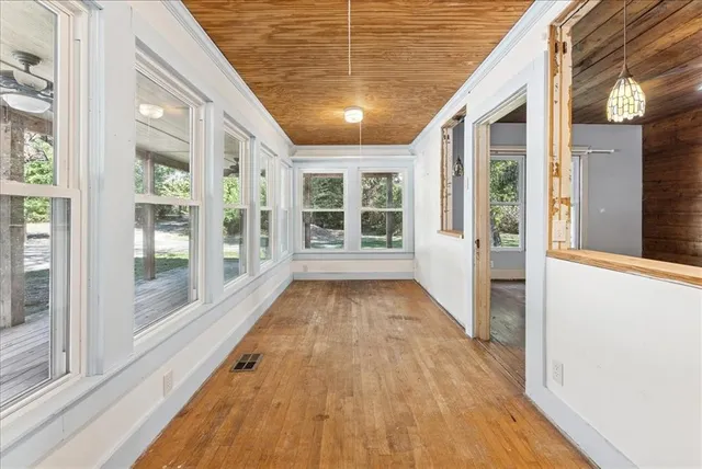 a view of a porch with wooden floor and windows