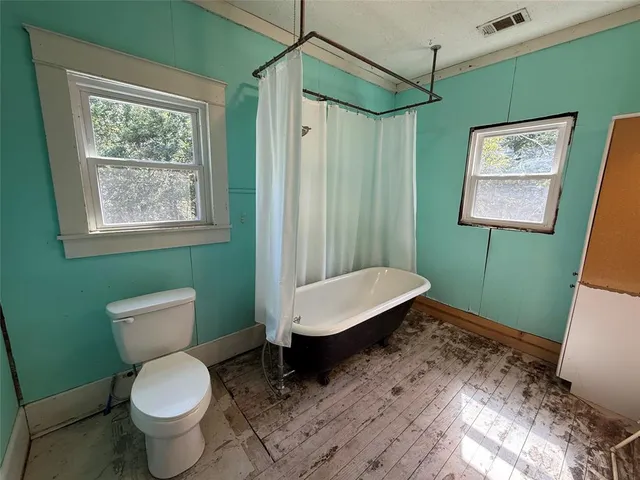a bathroom with a toilet a sink and a window