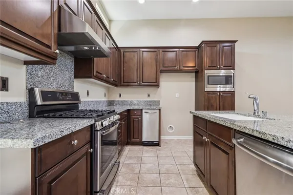 a kitchen with stainless steel appliances granite countertop a stove sink and cabinets