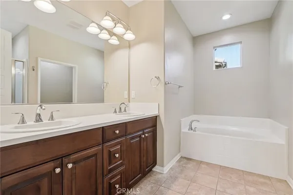 a bathroom with a tub a sink and mirror