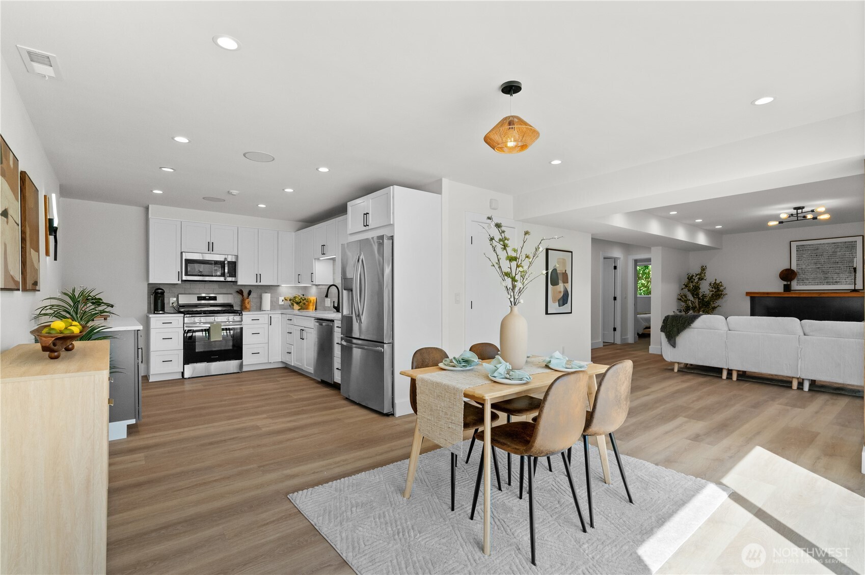 12208 Southeast 192nd Street Renton, WA 98058 - Photo 30 of 40 a kitchen with stainless steel appliances a dining table chairs stove and white cabinets