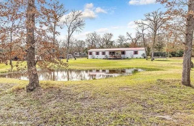 a view of a house with a yard and lake view