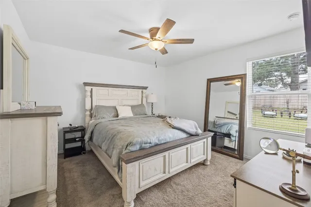 a bedroom with a bed and large windows