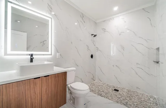 a bathroom with a sink a toilet and shower