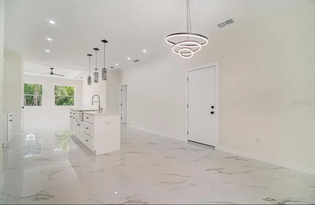 a view of a kitchen with refrigerator and white cabinets