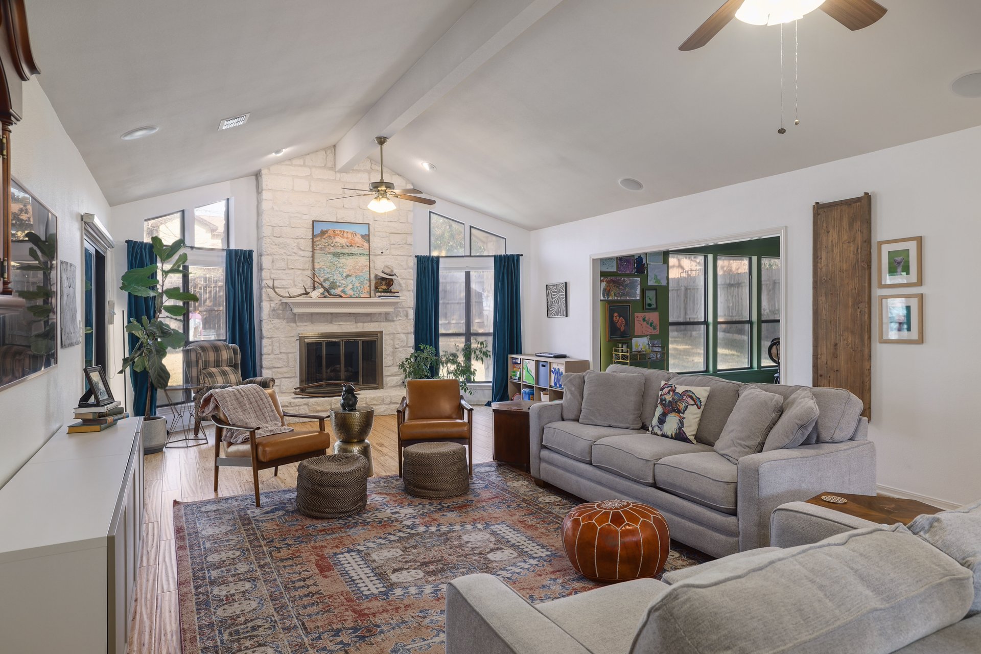 5500 Cedro Trail Austin, TX 78731 - Photo 6 of 34 Living area featuring a ceiling fan, a stone fireplace, plenty of natural light, beamed ceiling, and wood finished floors