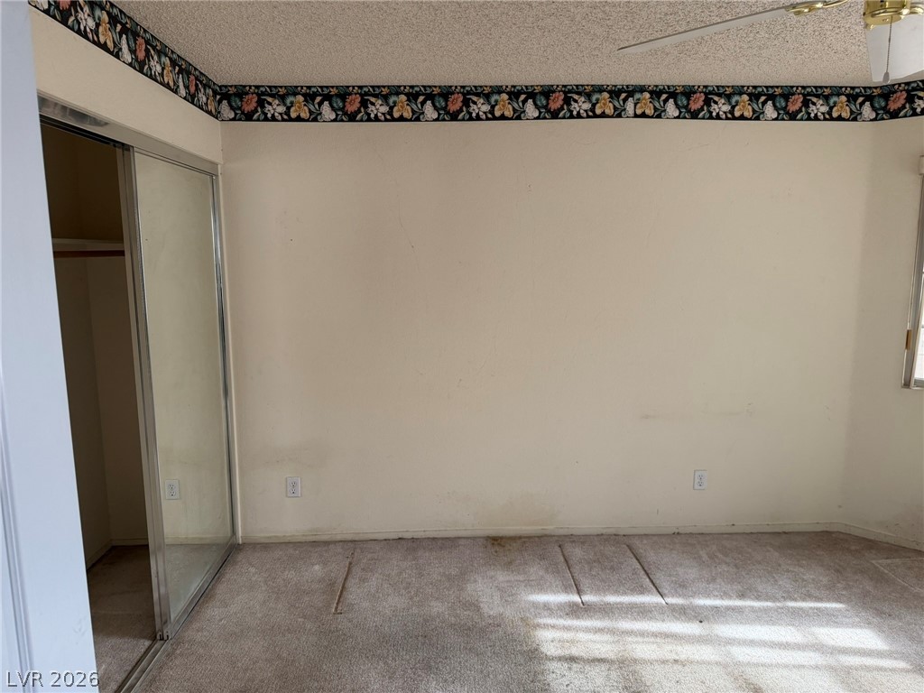 277 Gentle Bay Avenue Henderson, NV 89074 - Photo 35 of 43 This spacious room features a mirrored closet and a ceiling fan, offering both utility and comfort.
