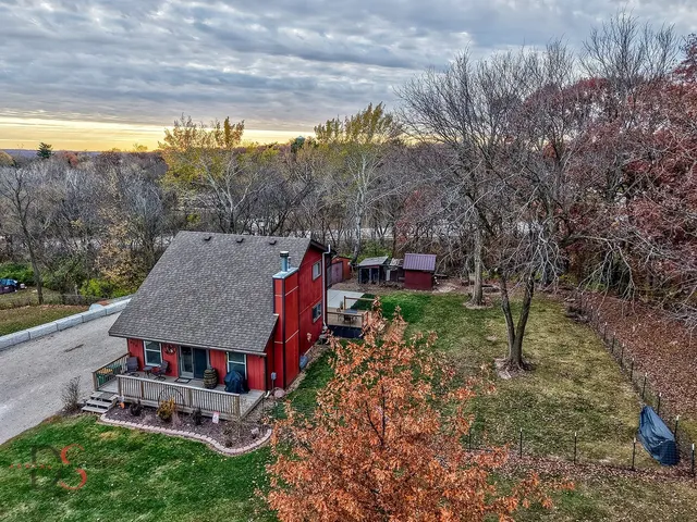 a view of a big house with a big yard and large trees