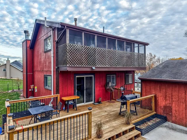 a view of a house with a chairs and wooden fence