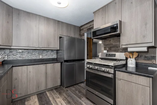 a kitchen with stainless steel appliances granite countertop a sink and a refrigerator
