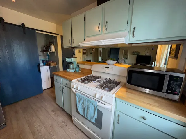 a kitchen with stainless steel appliances granite countertop a stove a sink dishwasher and a refrigerator