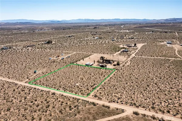 an aerial view of house with yard and mountain view in back