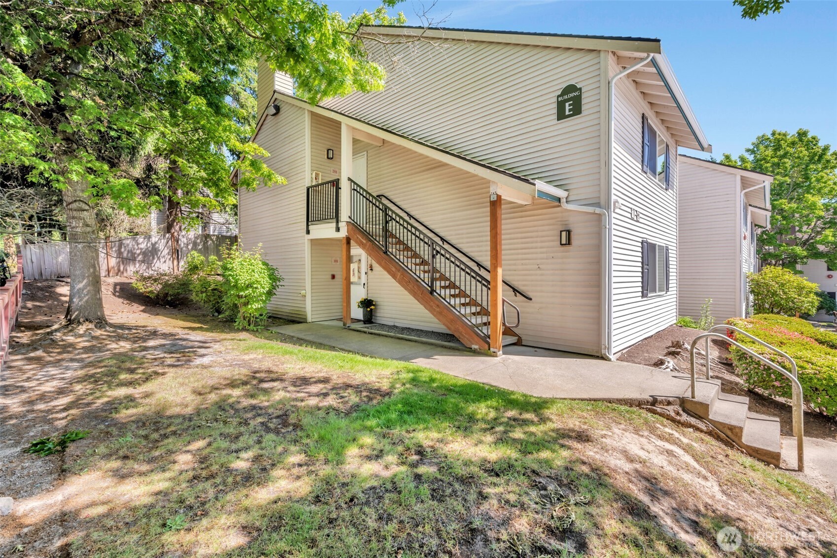 4231 Northeast 5th Street, Unit E101 Renton, WA 98059 - Photo 1 of 29 a backyard of a house with table and chairs