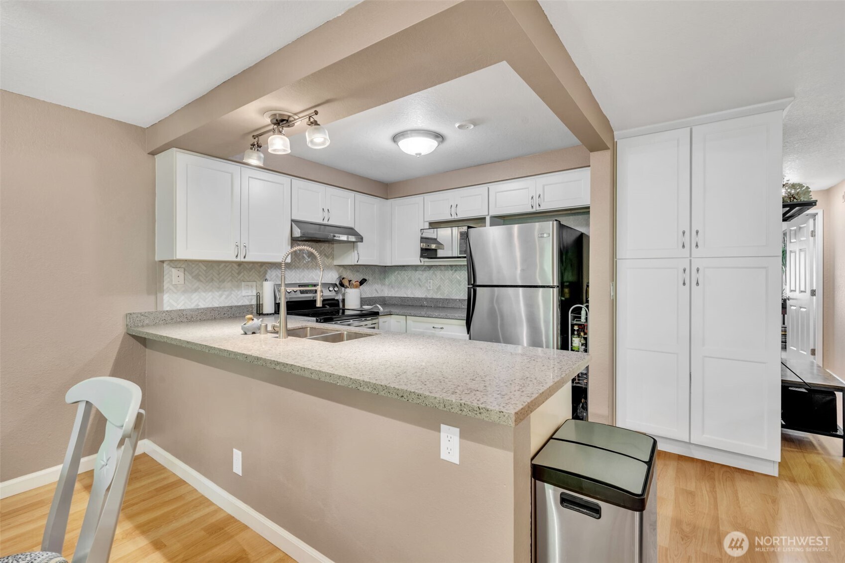 4231 Northeast 5th Street, Unit E101 Renton, WA 98059 - Photo 14 of 29 a kitchen with kitchen island a sink stainless steel appliances and refrigerator