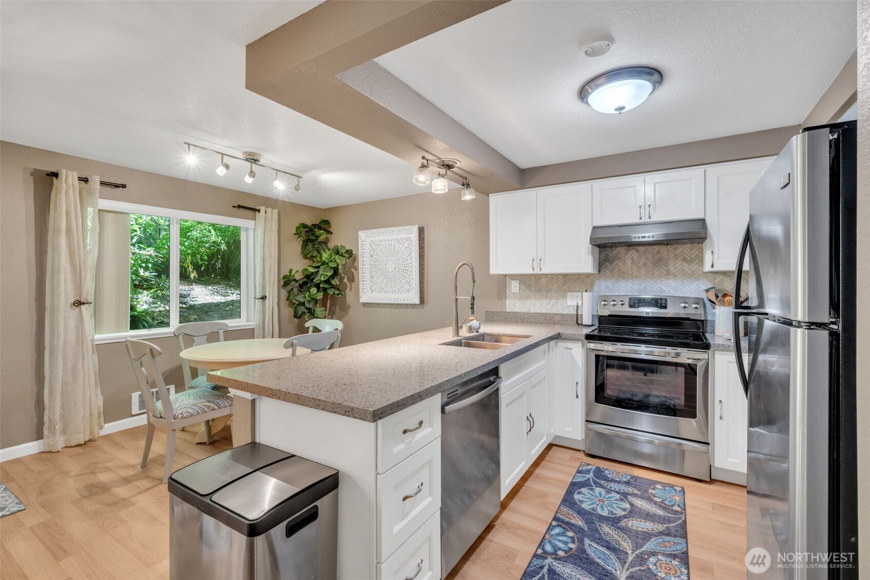 4231 Northeast 5th Street, Unit E101 Renton, WA 98059 - Photo 2 of 29 a kitchen with a stove a sink and a refrigerator
