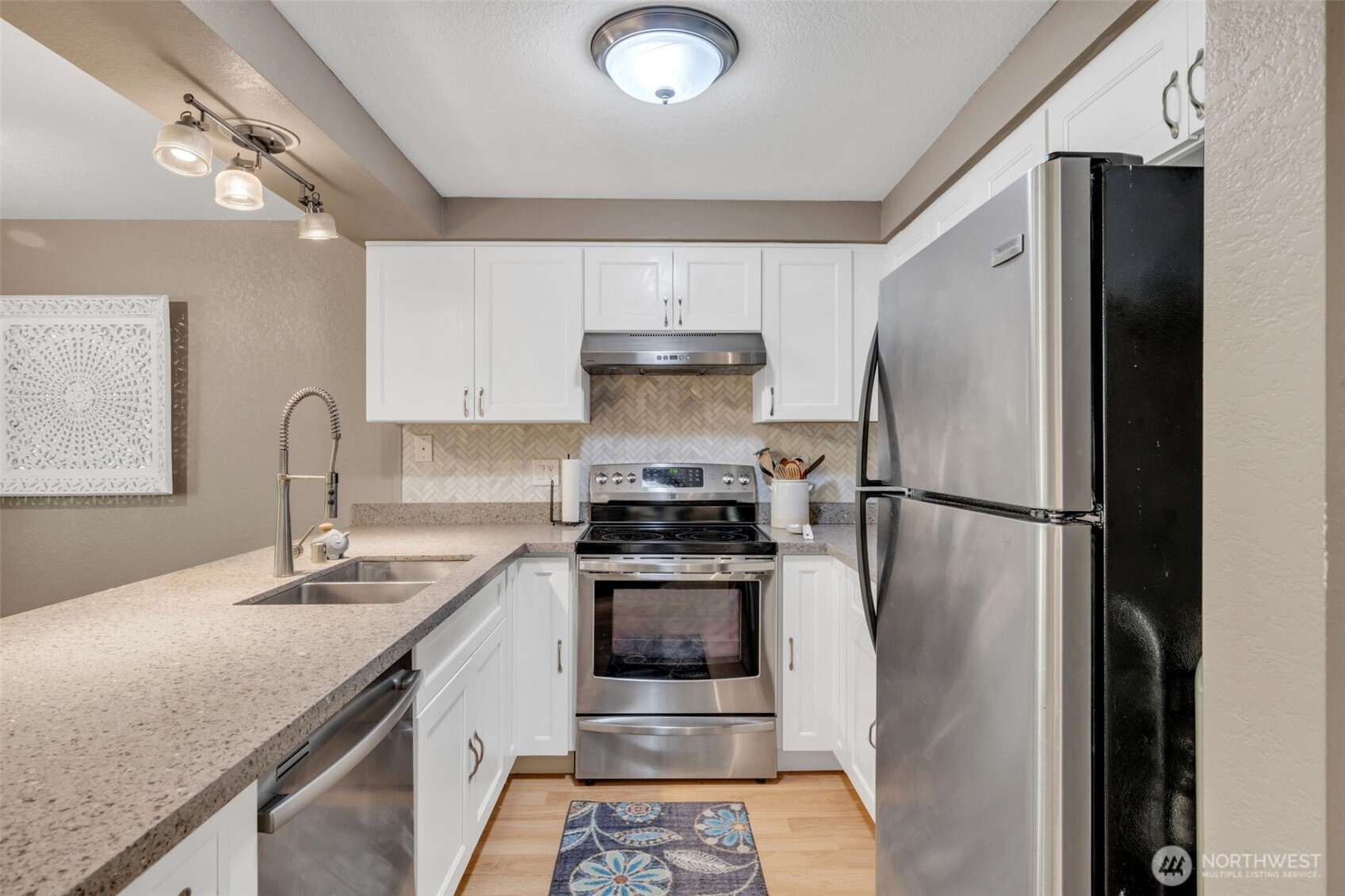 4231 Northeast 5th Street, Unit E101 Renton, WA 98059 - Photo 10 of 29 a kitchen with stainless steel appliances granite countertop a sink stove and refrigerator
