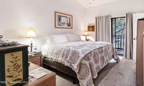 a spacious bedroom with a bed and chair