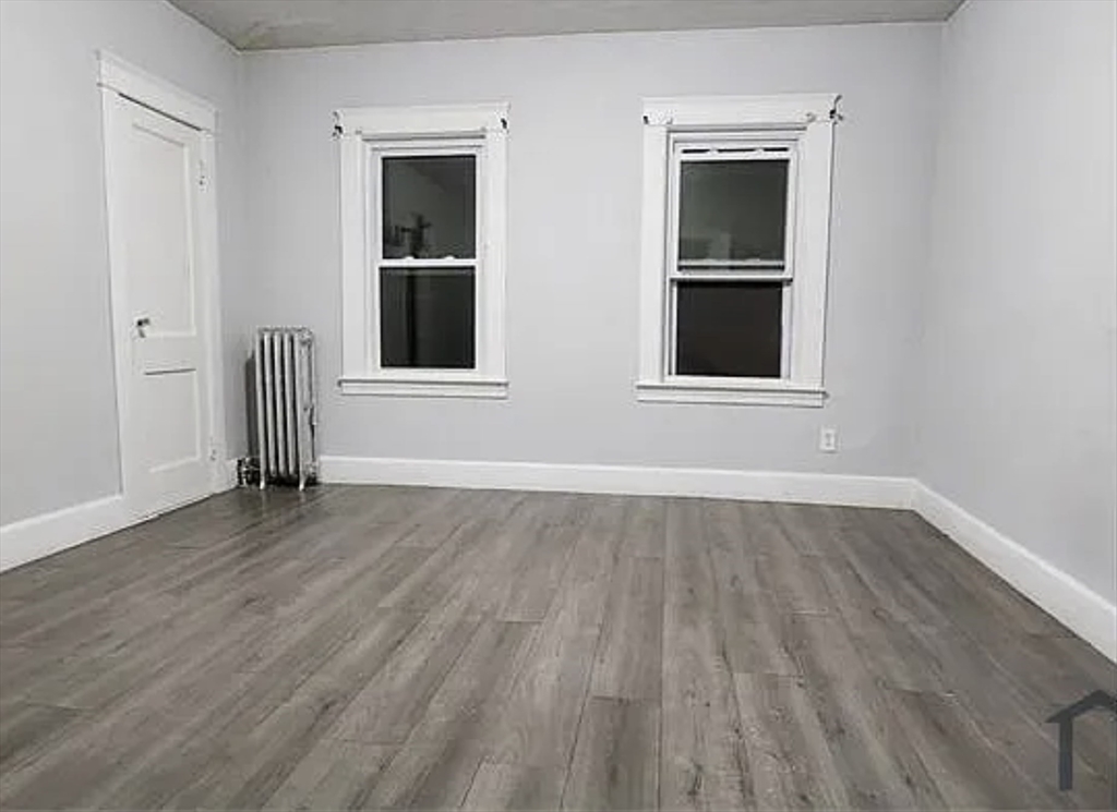 191 Eastern Avenue, Unit 2 Worcester, MA 01605 - Photo 2 of 6 a view of an empty room with wooden floor and a window