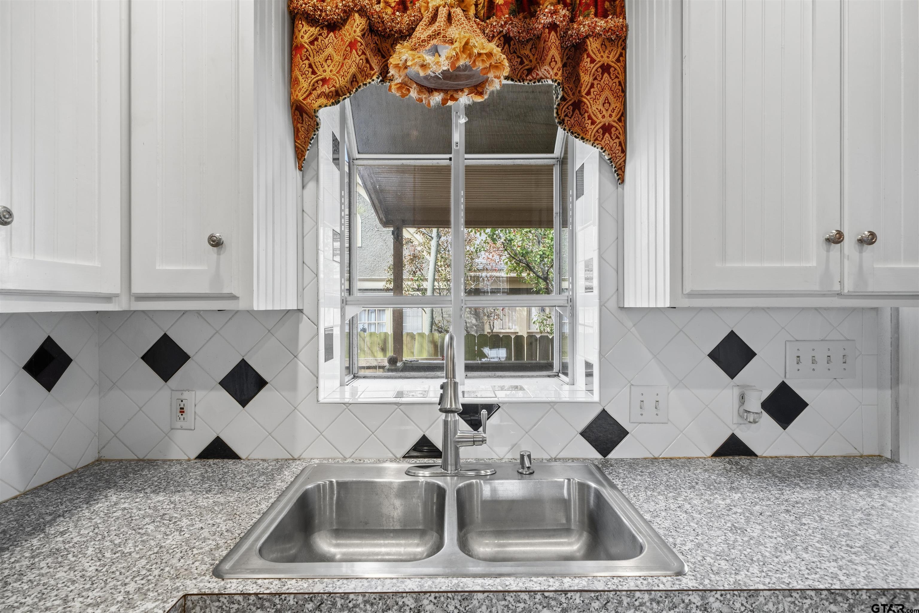 315 Mockingbird Lane Tyler, TX 75701 - Photo 12 of 33 a kitchen with a sink a stove and cabinets