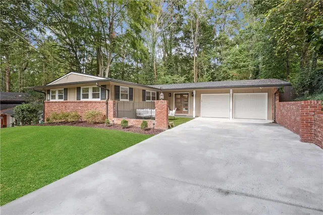 a front view of a house with a yard and green space