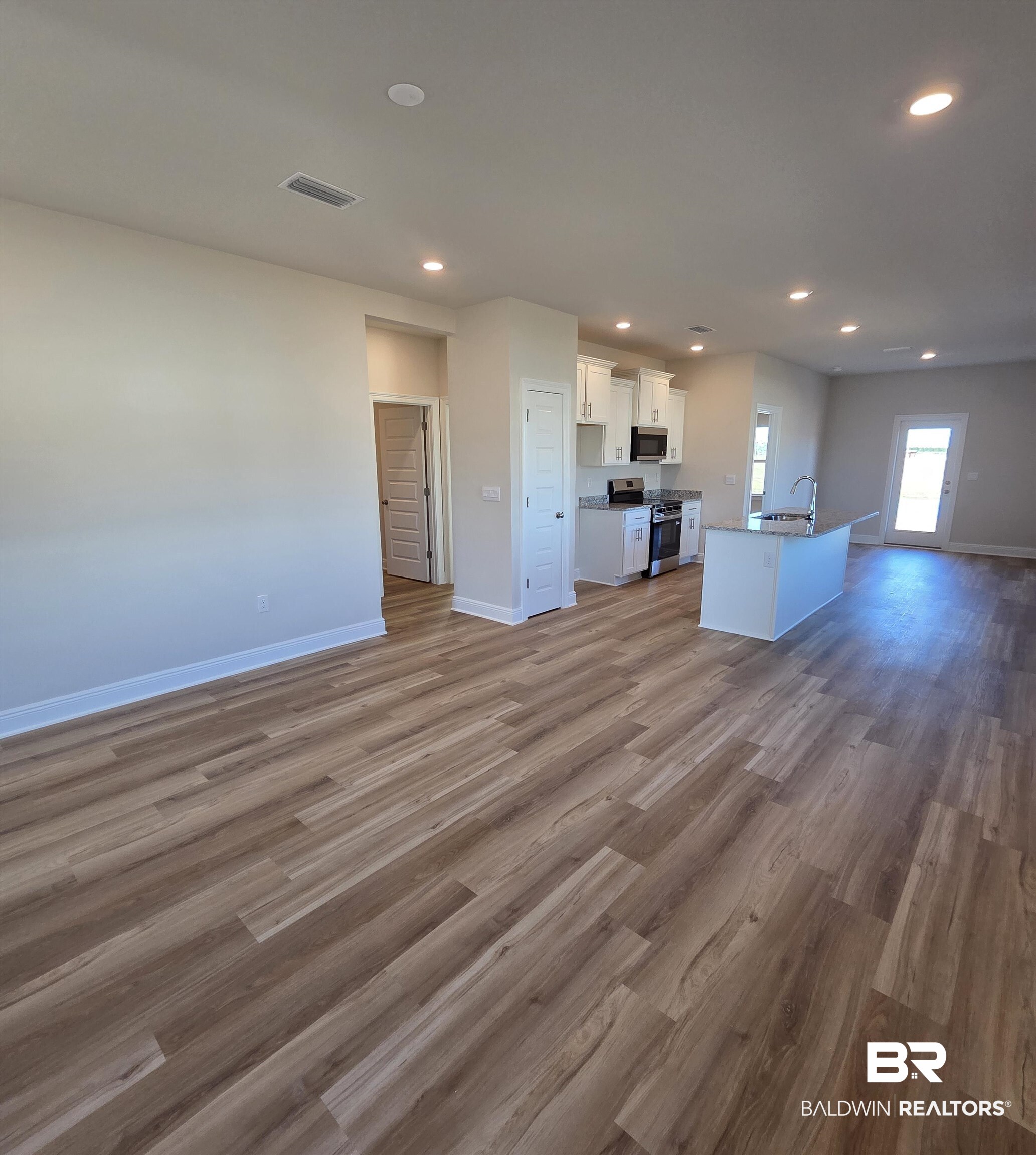 28133 Hallow Trail Elberta, AL 36530 - Photo 19 of 20 Kitchen with open floor plan, white cabinets, dark wood-type flooring, stainless steel appliances, and recessed lighting