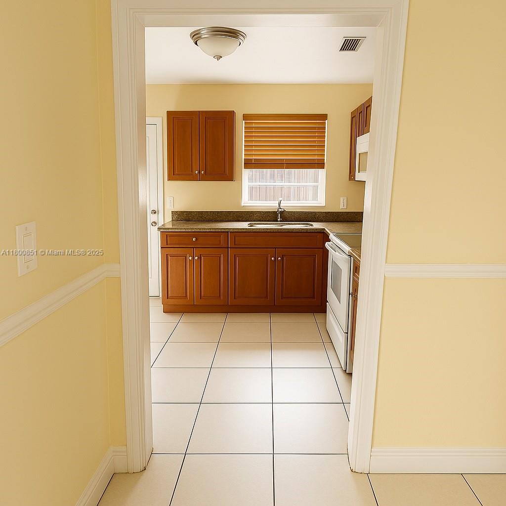1741 Southwest 17th Court Miami, FL 33145 - Photo 4 of 13 a bathroom with a granite countertop sink a mirror and a bathtub