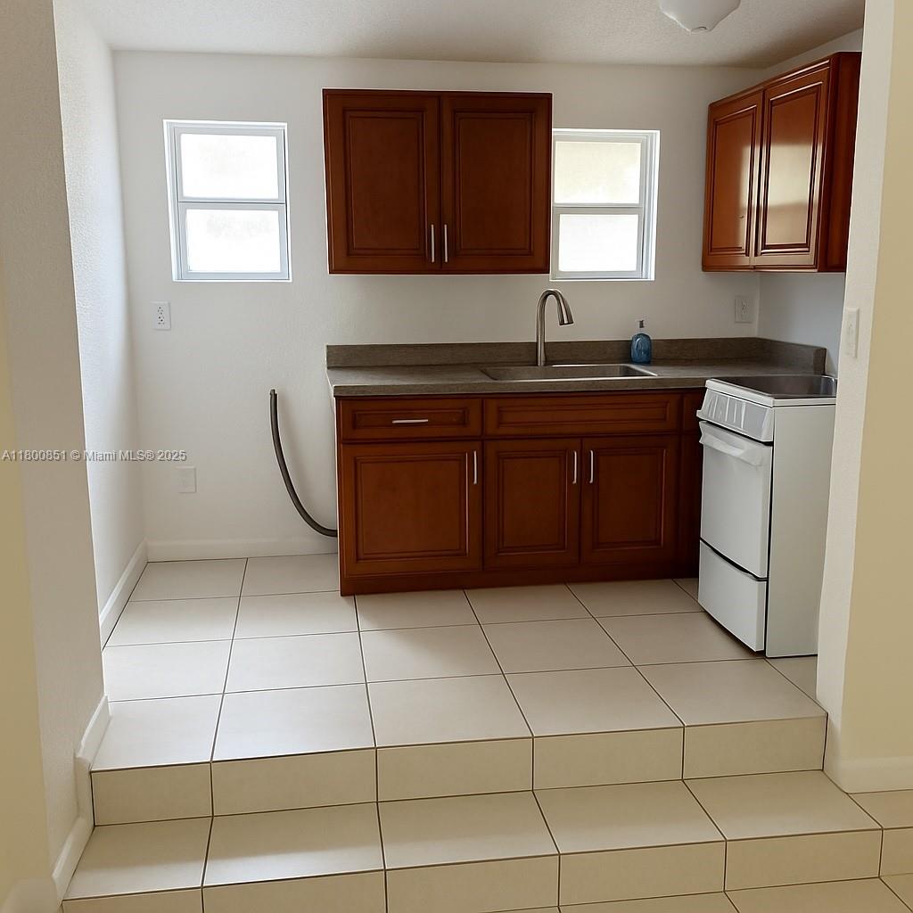 1741 Southwest 17th Court Miami, FL 33145 - Photo 10 of 13 a kitchen with a sink a stove and a cabinets