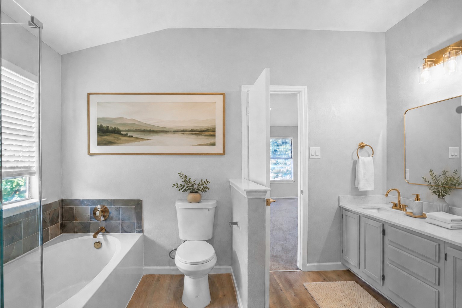 800 Smoke Signal Pass Pflugerville, TX 78660 - Photo 5 of 40 A refined bathroom featuring warm wooden flooring and a spacious tub, perfect for unwinding after a long day.