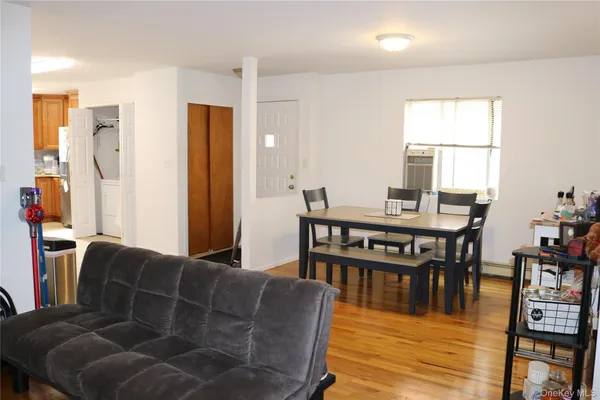 a living room with furniture a wooden floor and next to a window
