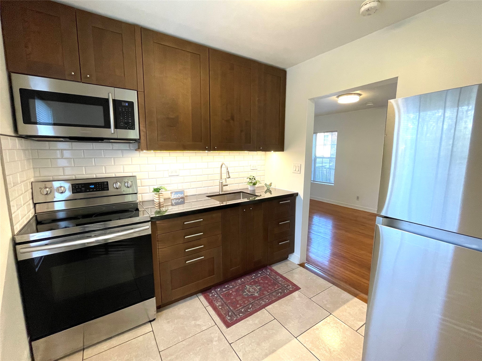 4334 Jefferson Street Houston, TX 77023 - Photo 28 of 31 a kitchen with stainless steel appliances kitchen island granite countertop a stove a microwave and a sink