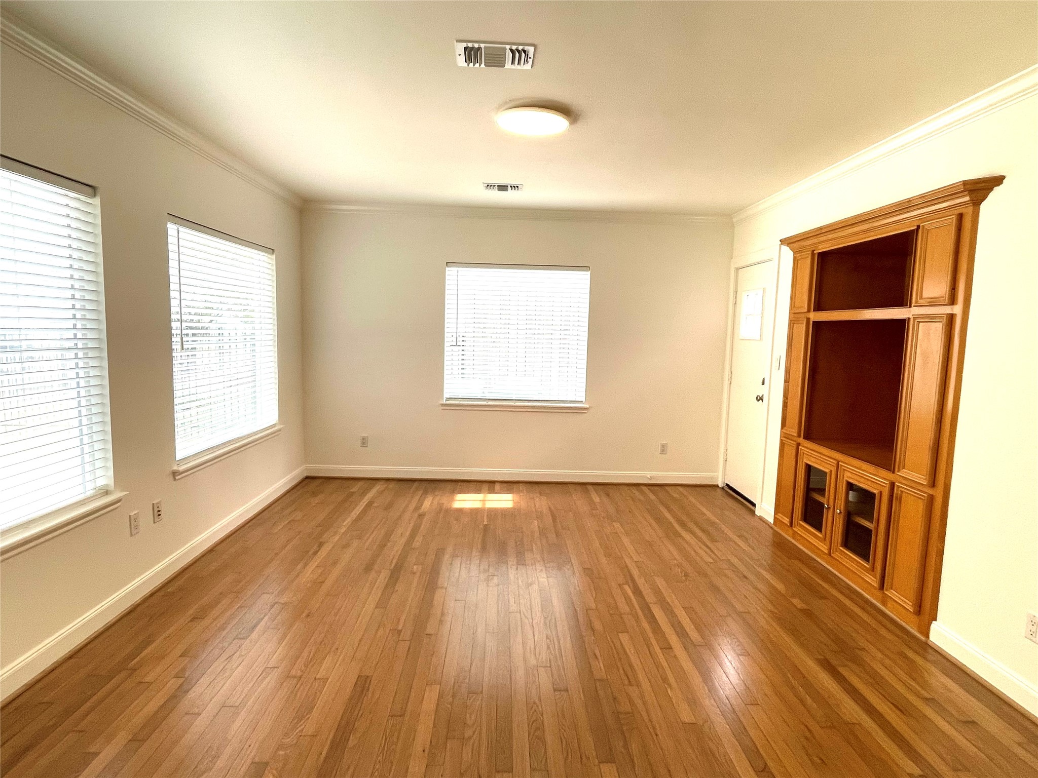 4334 Jefferson Street Houston, TX 77023 - Photo 5 of 31 an empty room with wooden floor and windows