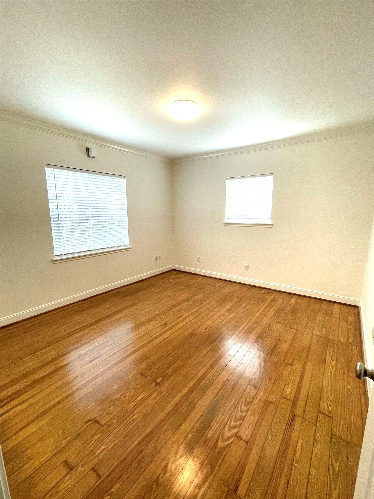 4334 Jefferson Street Houston, TX 77023 - Photo 7 of 31 an empty room with wooden floor and windows