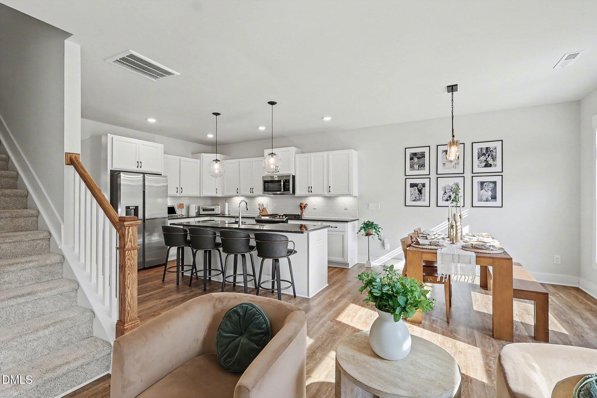235 Sneed Lane Fuquay-Varina, NC 27526 - Photo 8 of 63 a living room with furniture kitchen view and a dining table