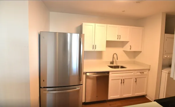 a kitchen with a refrigerator sink and cabinets