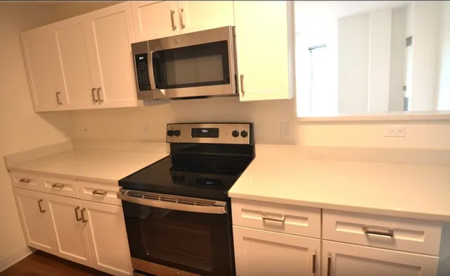 a kitchen with granite countertop cabinets stainless steel appliances and a sink