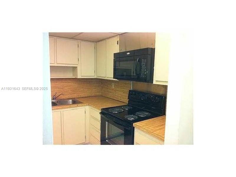 20860 San Simeon Way, Unit 3026 Miami, FL 33179 - Photo 3 of 17 a kitchen with granite countertop a stove and a refrigerator