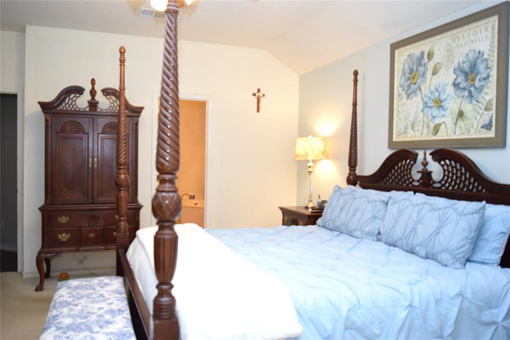 4201 Glistening Spring Rowlett, TX 75088 - Photo 16 of 33 Vaulted ceiling bedroom with light-toned walls, featuring wood-finish flooring and a ceiling fan