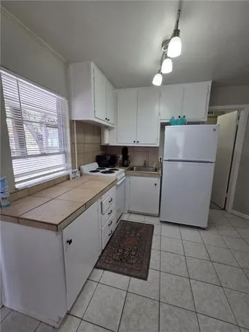 a kitchen with a cabinets a counter top space and a window