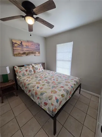 a bedroom with a bed and a lamp on the dresser