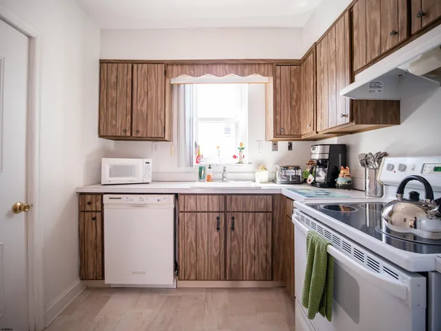a kitchen with a sink cabinets appliances and a window
