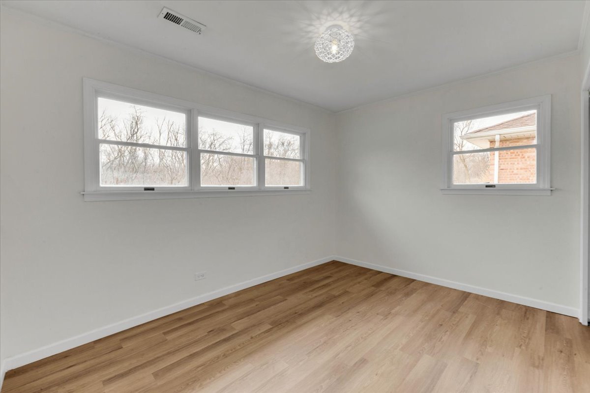 192 Monee Road Park Forest, IL 60466 - Photo 12 of 25 an empty room with wooden floor and windows