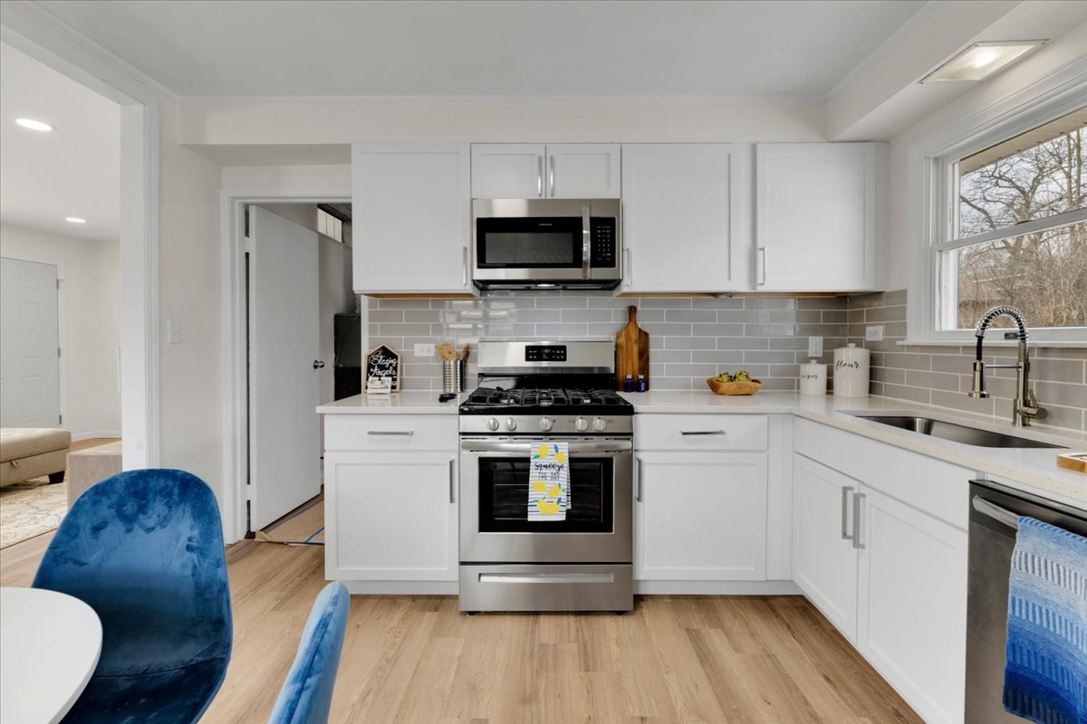192 Monee Road Park Forest, IL 60466 - Photo 7 of 25 a kitchen with stainless steel appliances a stove a sink a microwave a refrigerator and cabinets